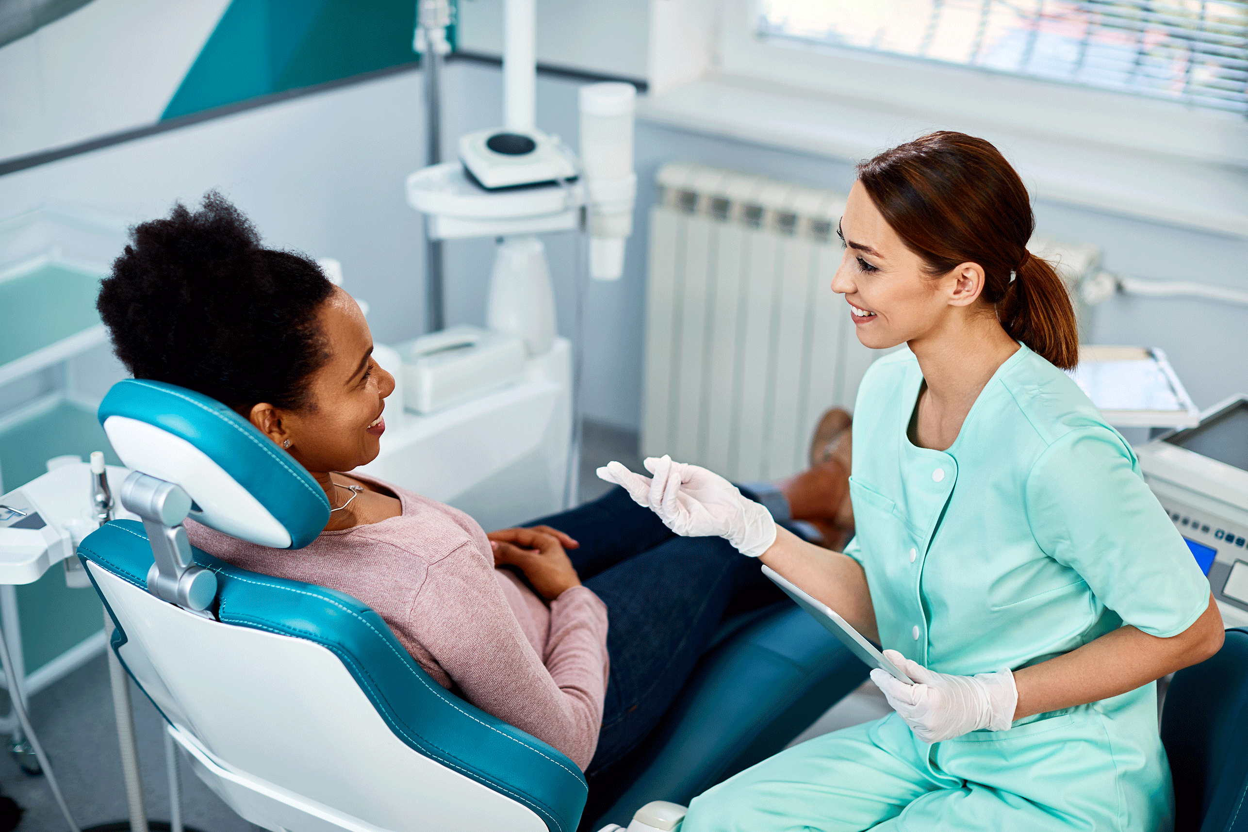 Zahnärztin berät Patientin auf Stuhl - PAR-Therapie GKV
