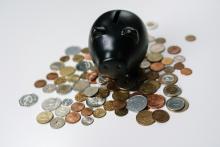 Schwarzes Sparschwein steht auf Kleingeld